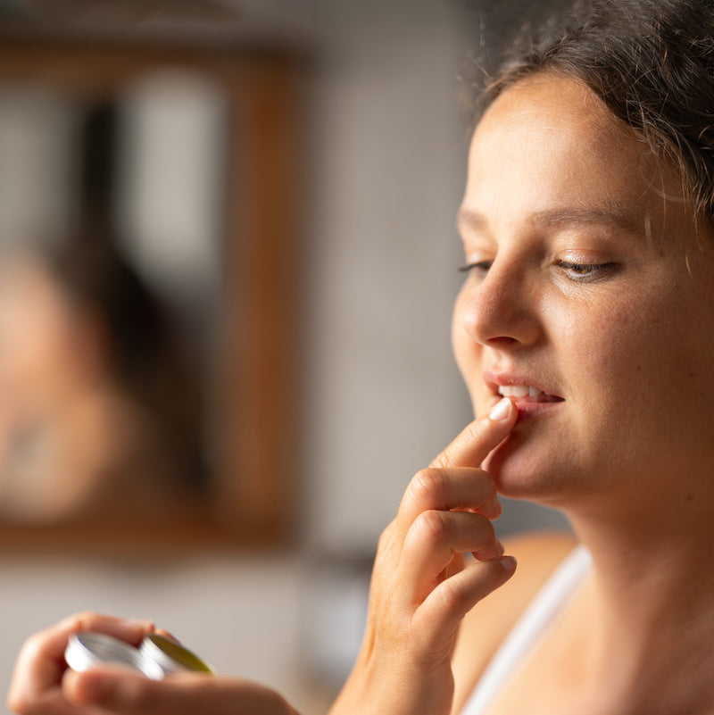 Weibliches Modell trägt Vogellisi Balsam auf Lippen auf
